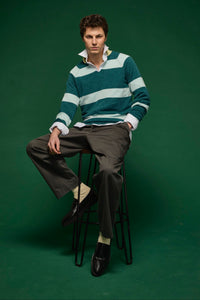 Man wearing rugby striped knitted polo shirt sitting on a stool