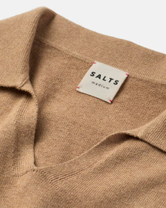 Close-up of a beige sweater with a 'SALTS' label on a white background